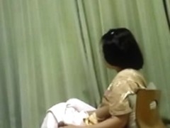 Mature Asian wife gives her husband a handjob while watching TV
