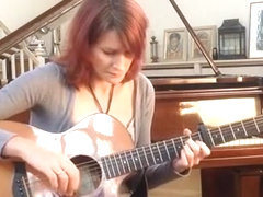 Redhead playing guitar down blouse and cleavage